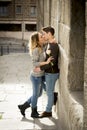 Candid portrait of beautiful European couple with rose in love kissing on street alley celebrating Valentines day Royalty Free Stock Photo