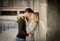 Candid portrait of beautiful European couple with rose in love kissing on street alley celebrating Valentines day Royalty Free Stock Photo