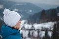 Candid portrait of boy with childish joyful smile in winter white hat and blue jacket. Real portrait of natural smiling teenager