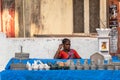 Candid portrait of a female street vendor selling stone pestles in the city