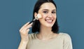 Candid portrait of a happy brunette young woman looking to the camera and making makeup with a brush herself Royalty Free Stock Photo