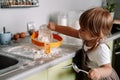 Candid portrait of little girl helps her mother to prepare cookies. Cute kid with flour in kitchen Royalty Free Stock Photo