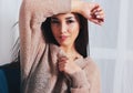 Candid portrait of sensual smiling asian girl young woman with dark long hair in cozy beige sweater sitting on blue vintage chair Royalty Free Stock Photo