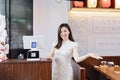 Candid portrait of young asian woman wearing traditional dress named cheongsam and smiling in cafe. Chinese counter for Royalty Free Stock Photo