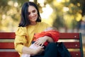 Happy Mother Holding Baby on A Bench in the Park Royalty Free Stock Photo