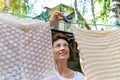 Candid real life portrait of young adult beautiful attractive caucasian woman hanging up fresh washed family clothes on Royalty Free Stock Photo