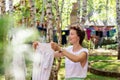 Candid real life portrait of young adult beautiful attractive caucasian woman hanging up fresh washed family clothes on Royalty Free Stock Photo