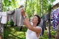 Candid real life portrait of young adult beautiful attractive caucasian woman hanging up fresh washed family clothes on Royalty Free Stock Photo