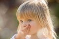 Candid serious thinking or sad young baby caucasian blonde girl portrait outdoor Royalty Free Stock Photo