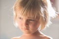Candid serious thinking or sad young baby caucasian blonde girl with small scratch portrait at home Royalty Free Stock Photo