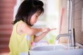 Candid short one little Asian girl washing her hands. She casually scrubbed the soap on her two hands intently and joyfully. Royalty Free Stock Photo