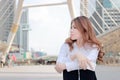 Candid shot of attractive young Asian business woman thinking and dreaming about something at city background. Royalty Free Stock Photo