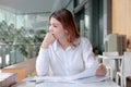 Candid shot of attractive young Asian business woman thinking and resting one`s eyes on the desk in office.