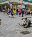 Candid shot of crazy tourist posing on top of brass sewer worker statue, Bratislava, Slovakia