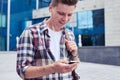 Candid student listens to music while searching something in phone