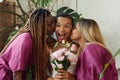 Candid two bridesmaids kissing bride on cheeks during wedding ceremony Royalty Free Stock Photo