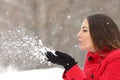 Candid woman in red blowing snow in winter