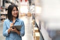 Candid of young attractive asian woman, auditor or trainee staff working in warehouse store counting or stocktaking inventory by Royalty Free Stock Photo