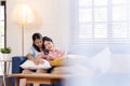 Candid of young attractive happy asian lesbian couple enjoy holiday weekend sitting on couch in living room at home feeling relax Royalty Free Stock Photo