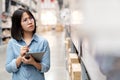 Candid young unhappy asian woman, auditor or employee feeling confused in warehouse store. Young girl puzzled face, expressing Royalty Free Stock Photo