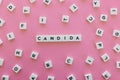 Candida word made of square letter word on pink background.