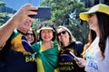 Candidate for Senator Nise Yamaguchi taking a selfie in the sun with voters on Paulista avenue