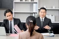 Candidate woman from behind having interview for new job by two businessman managers, giving CV resume to human resources officer Royalty Free Stock Photo