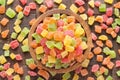 Candied fruit, colorful cubes in wooden bowl, top view