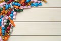 Candies in colorful wrappers on beige wooden table, flat lay. Space for text Royalty Free Stock Photo