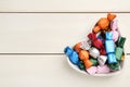 Candies in colorful wrappers on white wooden table, top view. Space for text Royalty Free Stock Photo