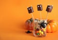 Delicious candies decorated as monsters on orange background, space for text. Halloween treat Royalty Free Stock Photo