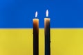 Candle on the background of the Ukraine flag. burning candle on the background of the Ukraine flag. Victims of cataclysm or war