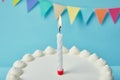 Candle on birthday cake on blue background Royalty Free Stock Photo