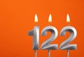 122 candle - Birthday celebration on orange background