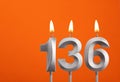 136 candle - Birthday celebration on orange background