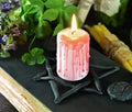 Candle on black magic book with clover Royalty Free Stock Photo