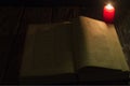 Candle and a book of the Bible on wooden background at night Royalty Free Stock Photo