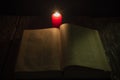 Candle and a book of the Bible on wooden background at night Royalty Free Stock Photo