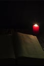 Candle and a book of the Bible on wooden background at night Royalty Free Stock Photo