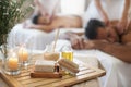 Candle, brush and couple in spa to relax on bed with luxury pamper treatment tools on table in hotel. Beauty, facial Royalty Free Stock Photo