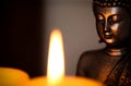 A candle and Buddha statue