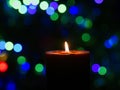 Candle is burning against blurred lights Royalty Free Stock Photo