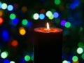 Candle is burning against blurred lights Royalty Free Stock Photo