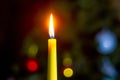 A candle burns near the Christmas tree at night against a dark background Royalty Free Stock Photo