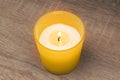 The candle burns in a yellow glass. Fragrant candles, gentle warm fire