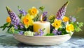 Candle Centerpiece in Ceramic Bowl with Mixed Spring Flowers.Celebration spring holiday Easter, Spring Equinox day, Ostara Sabbat
