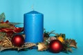 Candle and Christmas decorations on blue background Royalty Free Stock Photo