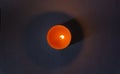 Candle on dark luxury night background. Black table, top view. Candles Burning at Night. Orange taper burning in focus, foreground