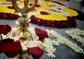 Candle and deepam stand with flowers background during Onam festival.