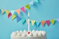 Candle on delicious birthday cake on blue background